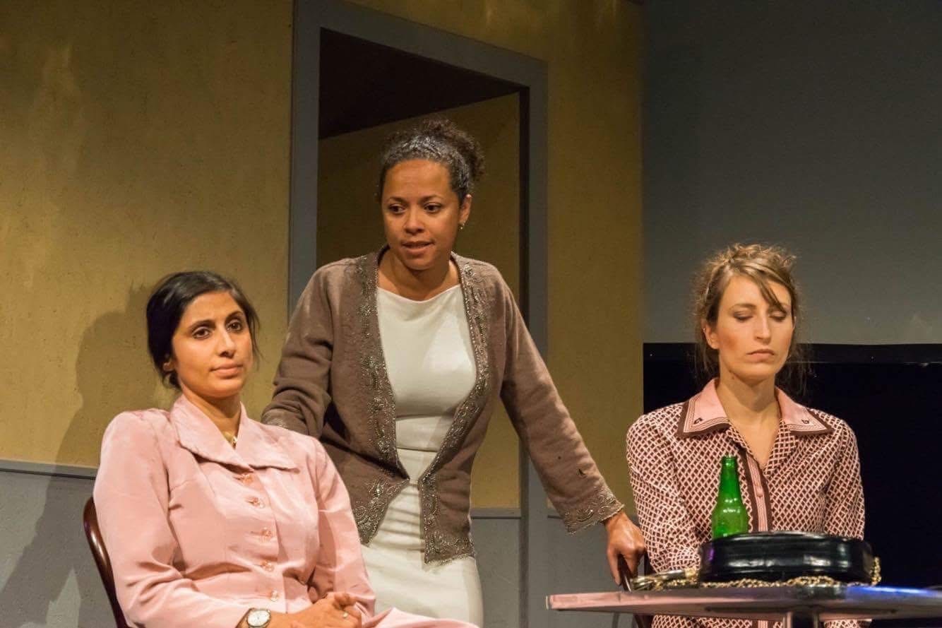 Three women around a table in An Enemy of the People.
