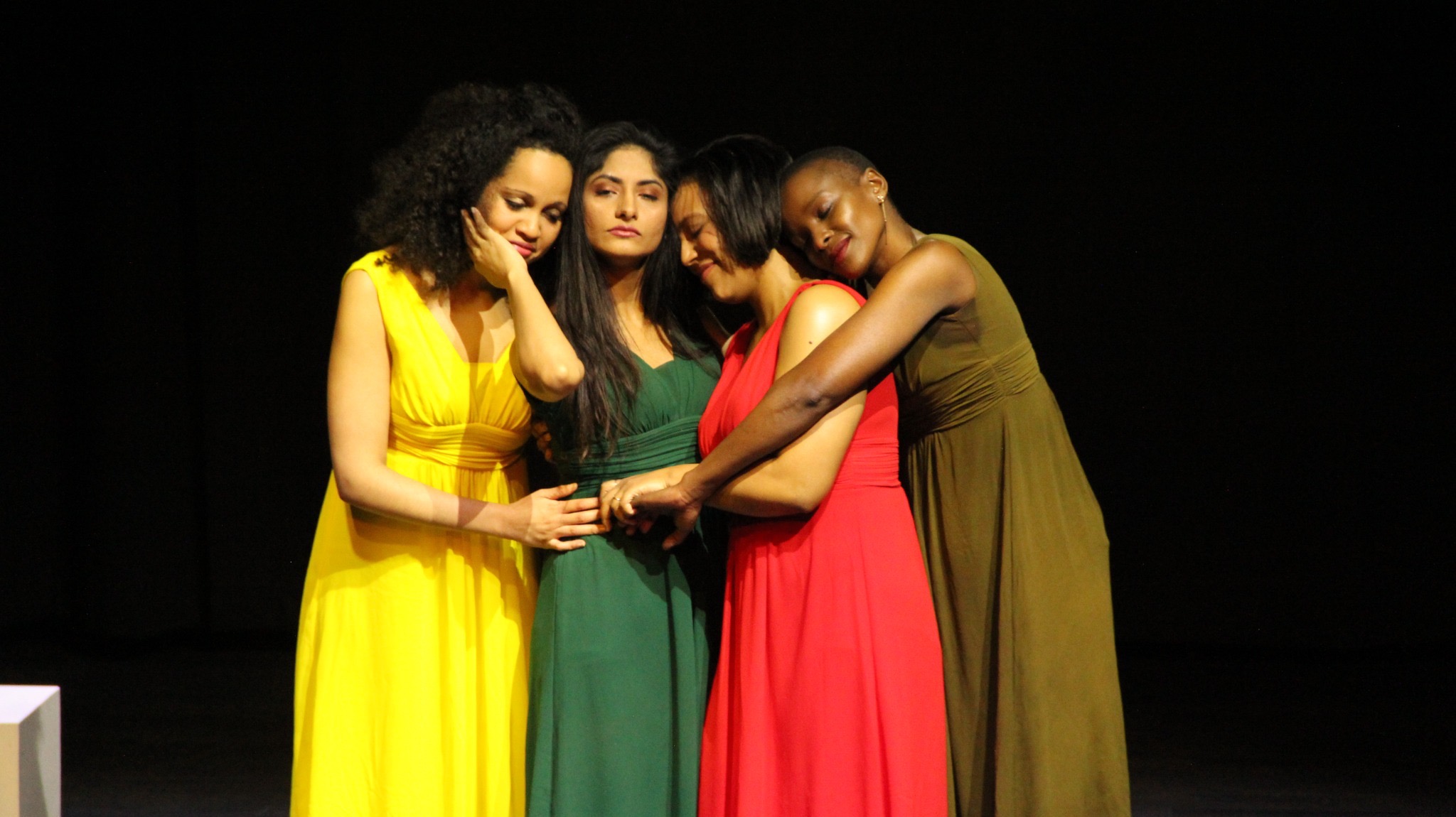 Four women arranged in an embrace of sisterhood and composure.