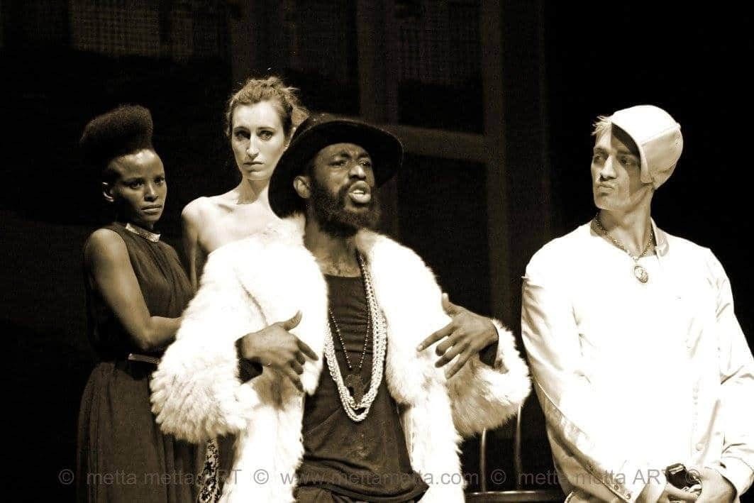 Sepiafarvet trioscene fra Købmanden i Venedig med en central figur i pelsfrakke flankeret af to andre.