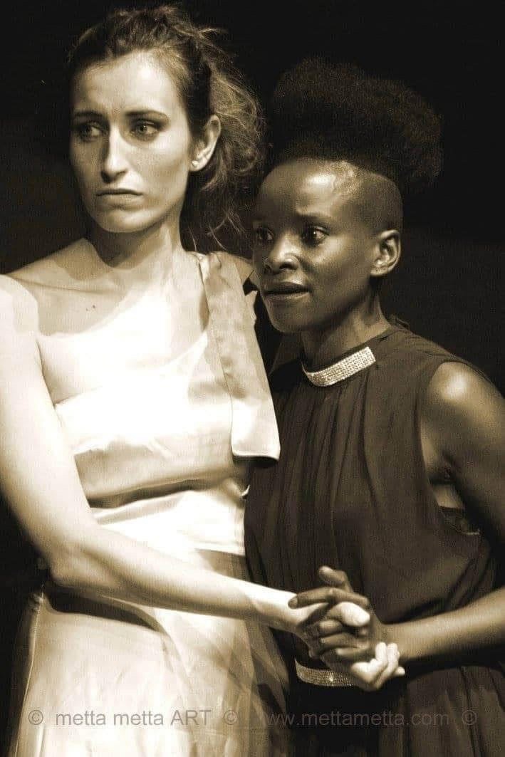 Sepia production still showing Jessica and Lora holding hands in The Merchant of Venice.