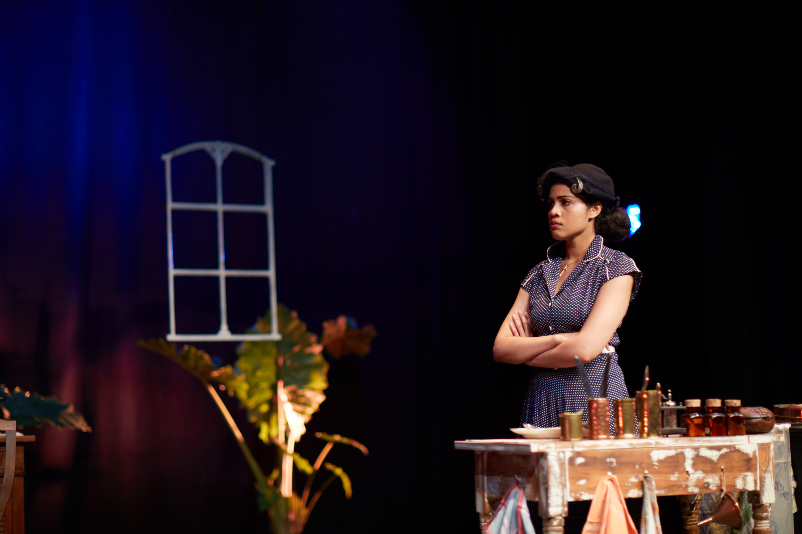 Christine standing with crossed arms in a severe act-two still.